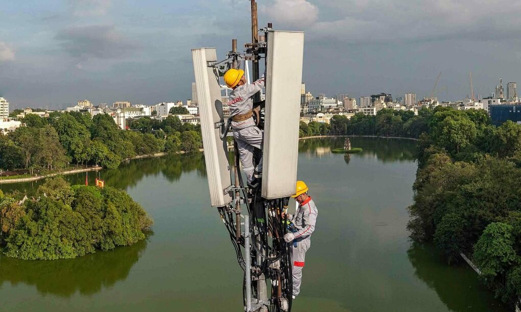 Kỹ thuật viên đang làm việc trên một cột viễn thông ở Hà Nội.